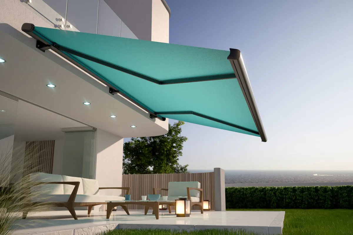 Teal cassette awning extended above a lounge terrace with recessed spotlights in the soffit
