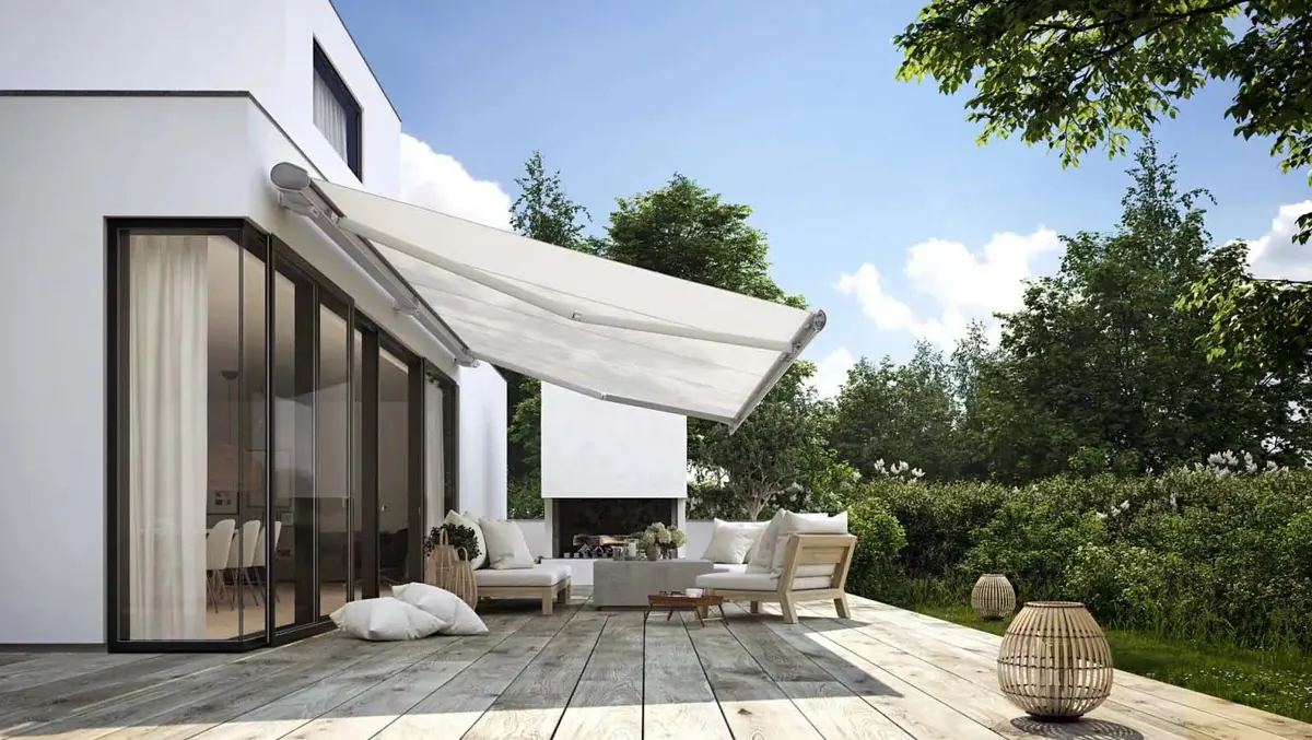 Large white cassette awning over a villa terrace with wooden decking and lounge seating