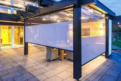 Terrace pavilion lit at dusk with a translucent white screen panel between dark posts