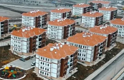 Aerial view of a housing estate of apartment blocks with red tiled roofs and a playground