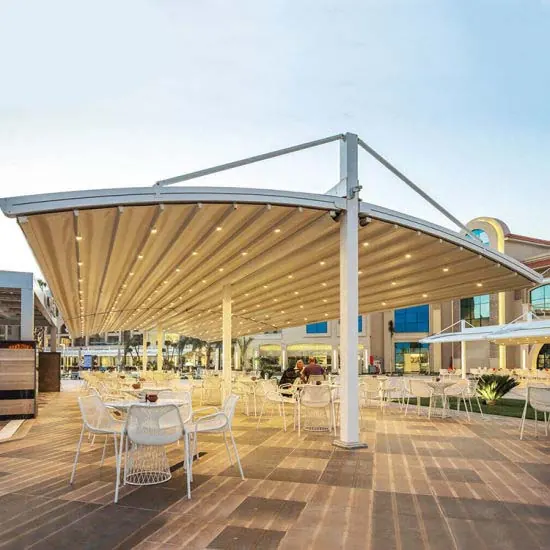 Oval canopy on a central mast over a cafe terrace with white chairs