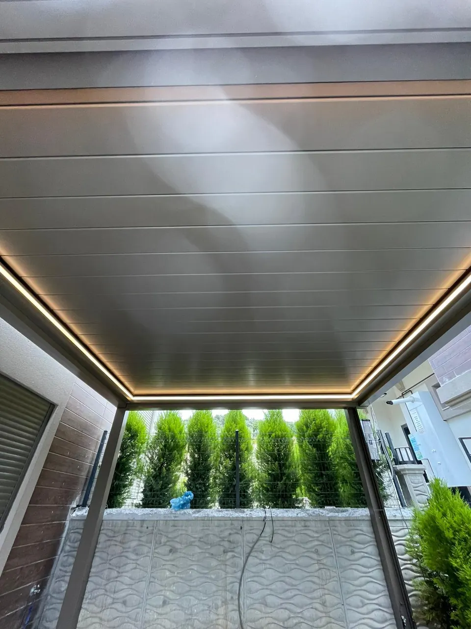 Underside of closed piston pergola louvres with warm LED line around the perimeter