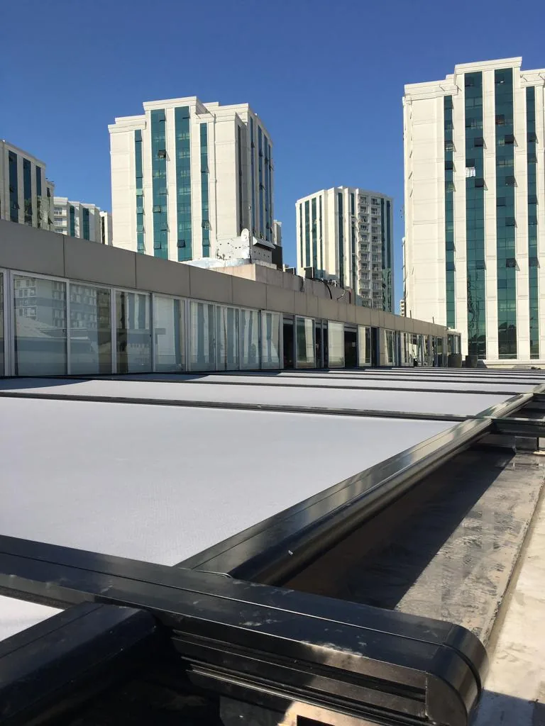 Rooftop zip screen over glazing with tall residential towers in the background