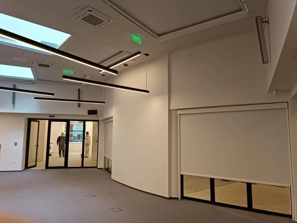 Interior hall with a large zip screen over glazed doors and skylights above