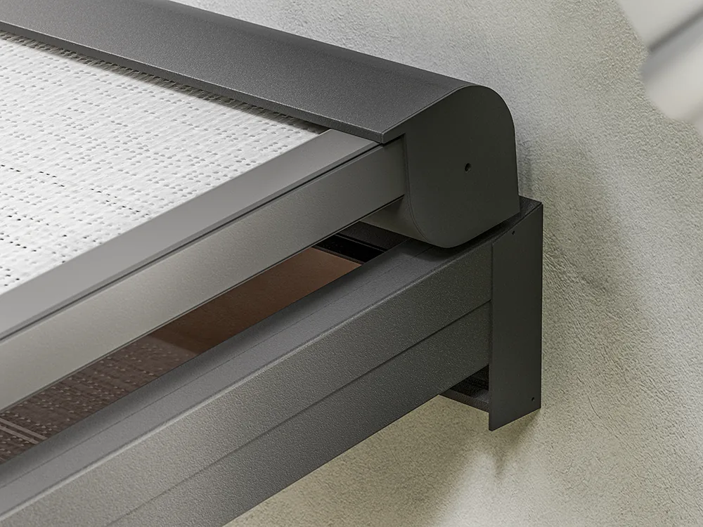 Dark aluminium headbox corner with translucent screen fabric visible beneath