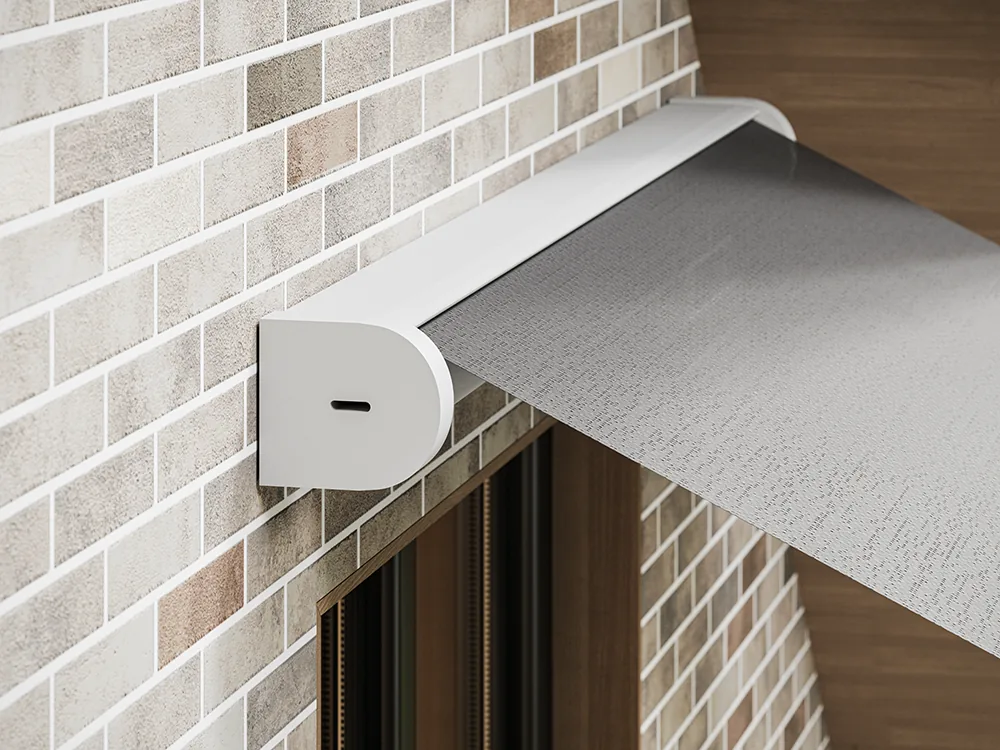 Rounded white headbox of a window awning with grey fabric leaving it above a brick-clad window