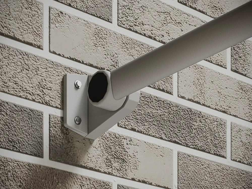 White tubular awning arm resting on a bolted wall bracket against textured brick