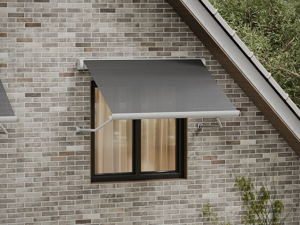 Window awning with dark fabric extended over a black-framed window on a brick gable wall